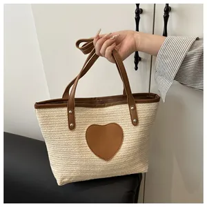 Détail d'un sac cabas tissé avec patch cœur en cuir marron et détails de rivets