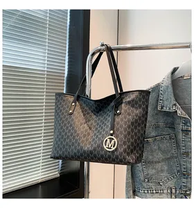 Detailansicht der großen Tote Bag mit M-Muster und Metallanhänger an einer Kleiderstange