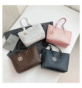 Detail view showing four colors of tote bags with monogram pattern and metal M charms