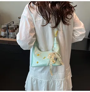 Λεπτομέρεια μέντας τσάντα hobo με δαντελένιο φιόγκο, πέρλες και μεταλλικά στοιχεία