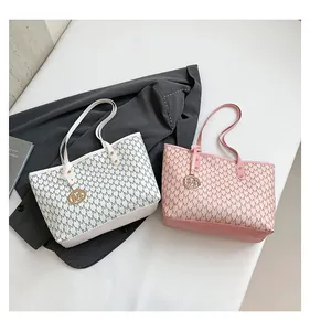 Detail of white and pink tote bags with M monogram pattern and metal logo charms