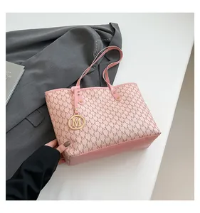 Detail of pink monogram tote bag with gold M-pendant and floral print leather texture