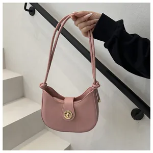 Vue détaillée du sac croissant rose avec fermoir doré et détail de bandoulière nouée