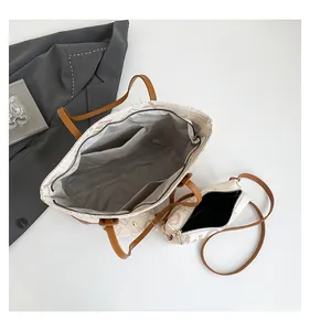 Vue de dessus du cabas blanc avec doublure grise et pochette bandoulière assortie