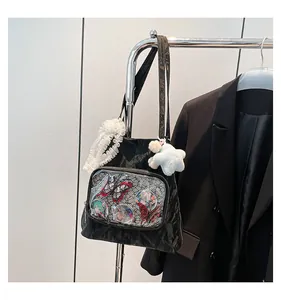 Detail of black pleated nylon Itabag with transparent pocket and anime character badges