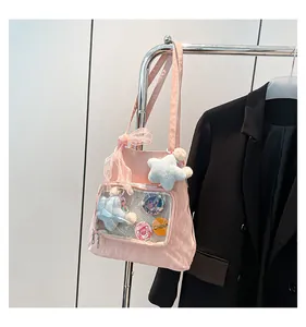 Detailed view of pink nylon ita bag with transparent window and colorful badges