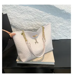 Detail of woven texture PU leather tote with golden deer charm and chain strap