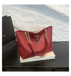 Detailed macro view of deep red woven texture leather with golden deer charm and chain