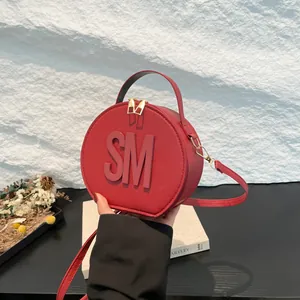 Fashionable red circular crossbody bag with SM embossed lettering and gold-tone hardware