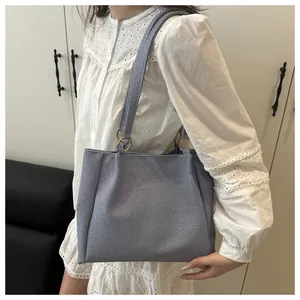 Detail of grey-blue canvas tote bag texture with metal ring strap connector on shoulder