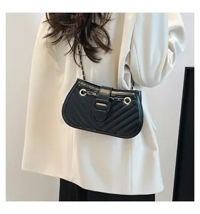 Détail du sac à bandoulière en cuir noir matelassé avec chaîne dorée et coutures en V