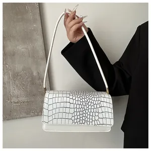Détail du sac à main blanc avec rabat motif crocodile noir et finitions dorées chic