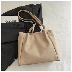 Close-up of beige canvas tote bag showing twill texture and metal ring shoulder strap