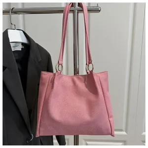 Detail of pink canvas tote bag showing textured fabric and gold metal ring connection