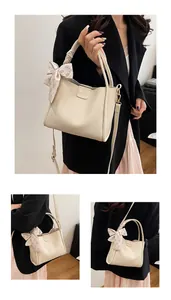 Close-up of beige lychee grain tote bag featuring a floral scarf knot and Fashion logo