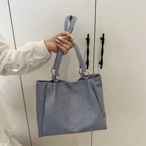 Minimalist blue striped tote bag with gold metal ring handles for daily commute