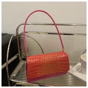 Détail du sac à main fuchsia gaufré crocodile avec finitions métalliques dorées