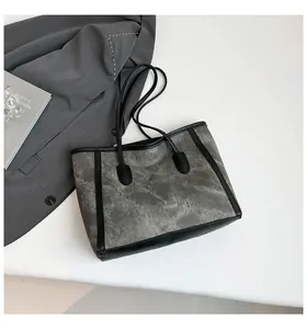 Overhead view of large color-block tote bag with grey marble texture and black leather trim