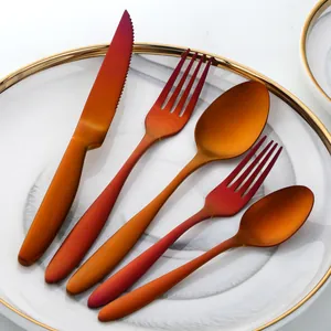 Five-piece modern matte gradient cutlery set on white marble plate with golden rim