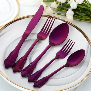 Gros plan d'un ensemble de couverts violets vintage en acier inoxydable sur une assiette