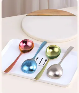 Détail de quatre cuillères colorées en titane en rose, bleu, vert et argent au fini mat