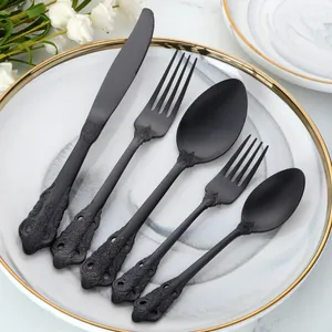 Vue détaillée du service de couverts en acier noir mat avec manches gaufrés de style rétro
