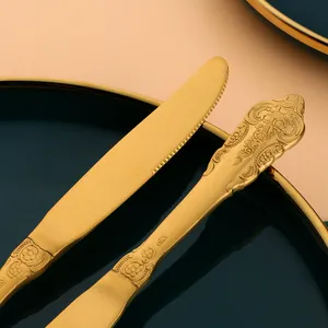 Gros plan d'un couteau à steak doré vintage avec manche à relief floral élégant