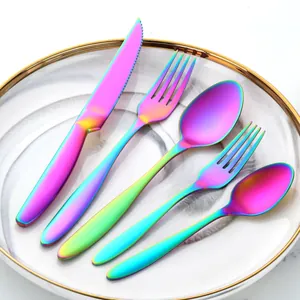 Detailed close-up of rainbow PVD stainless steel 5-piece cutlery set on marble plate