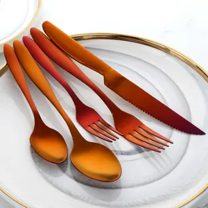 Detail of five-piece stainless steel cutlery set with red gradient matte titanium finish