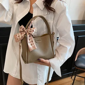 Vintage khaki bucket bag with printed scarf handle and elegant crossbody strap