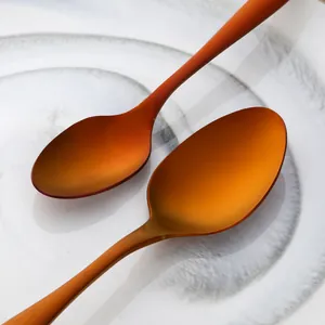 Macro shot of rose gold stainless steel spoons on minimalist ceramic plate