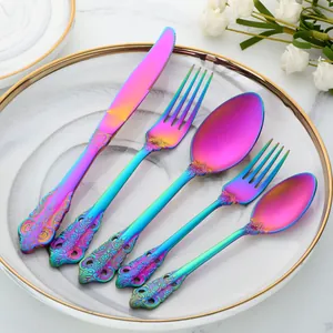 Ménagère 5 pièces en acier inoxydable arc-en-ciel avec reliefs vintage sur assiette blanche