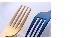 Macro shot of polished gold and blue 304 stainless steel fork tips on white plate