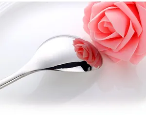 Detailed macro view of mirror-polished stainless steel spoon with clear floral reflection