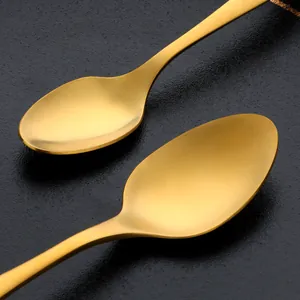 Five-piece gold titanium stainless steel cutlery set with a brushed finish on dark background