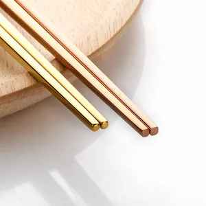 Macro view of gold and rose gold stainless steel chopsticks with polished square handles