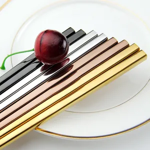 Baguettes en acier inoxydable 304 poli en quatre couleurs sur une assiette en porcelaine