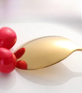 Vue macro montrant la finition dorée polie miroir d'une cuillère en acier inoxydable