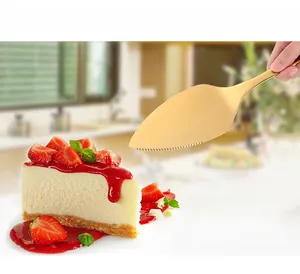 Detailed view of golden 304 stainless steel cake server with serrated edge in use