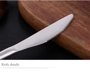 Vue macro d'un couteau à steak en acier inoxydable 304 avec lame dentelée sur bois