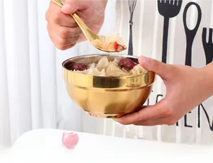 Detail of golden double-layer stainless steel bowl with spoon for insulated dining