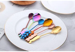 Vue détaillée des cuillères et de la fourchette colorées en acier 304 sur une assiette