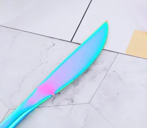 Detailed macro view of rainbow plated stainless steel steak knife with serrated blade