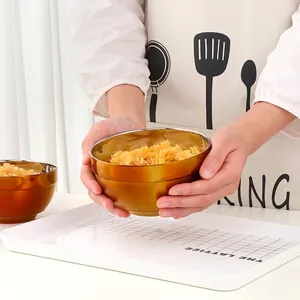 Golden double-layer 304 stainless steel insulated bowl being held with pasta inside