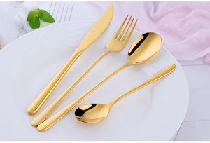 Set di posate in oro acciaio inox 304 con coltello forchetta e cucchiai su piatto bianco