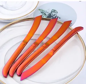 Detail van vier gekartelde roestvrijstalen steakmessen met een kleurrijke gradiënt finish