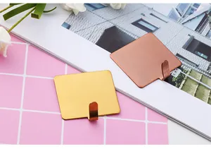 Detail of brushed gold and rose gold stainless steel square adhesive wall hooks