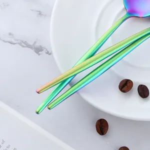 Regenbogenfarbener 304 Edelstahl-Kaffeelöffel mit langem Griff auf Marmorhintergrund