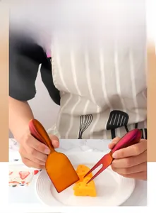Detail of gradient stainless steel cheese shovel and fork set on marble tabletop
