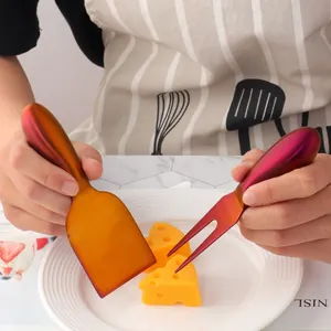 Rainbow stainless steel cheese knife and fork set on marble with yellow cheese